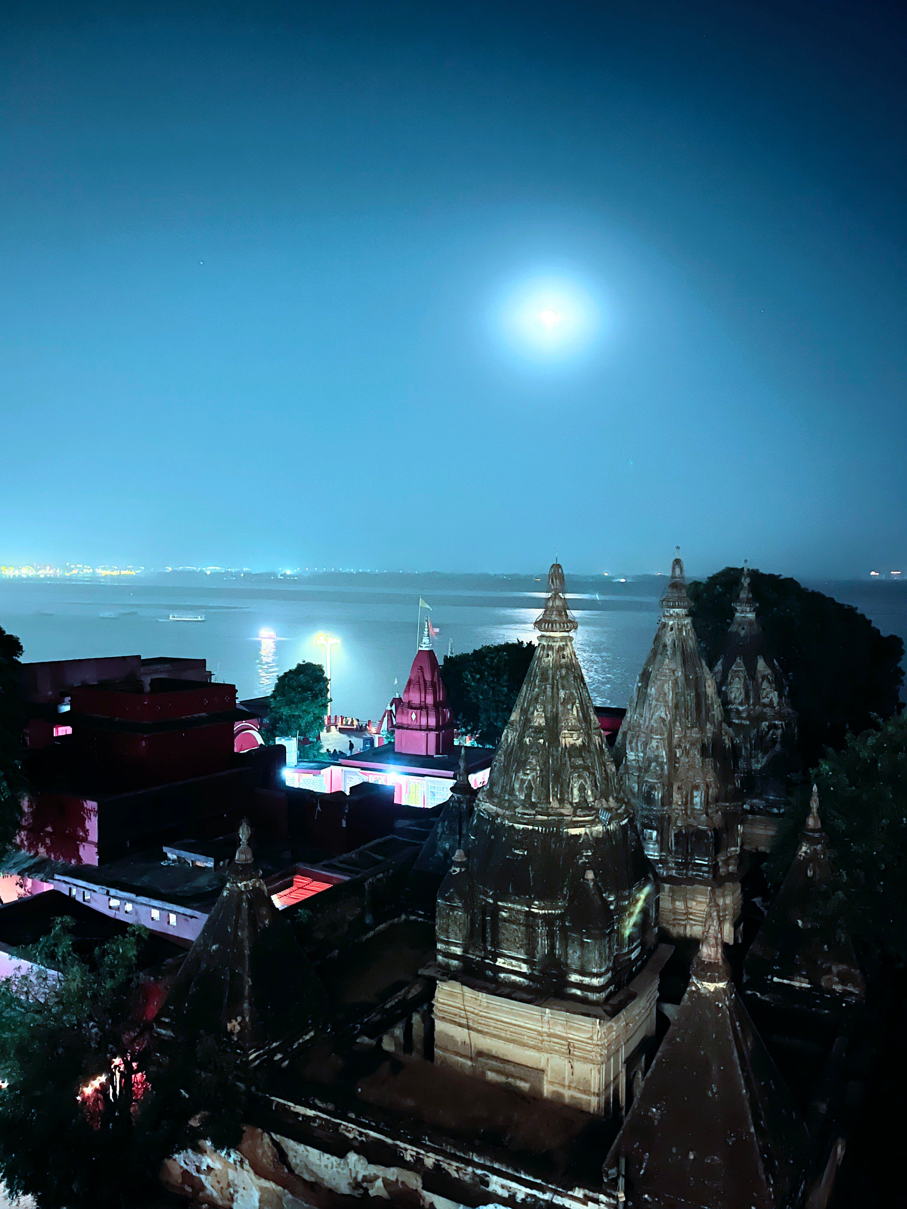 Full moon over the Ganges with temples reflected in the water — Varanasi night