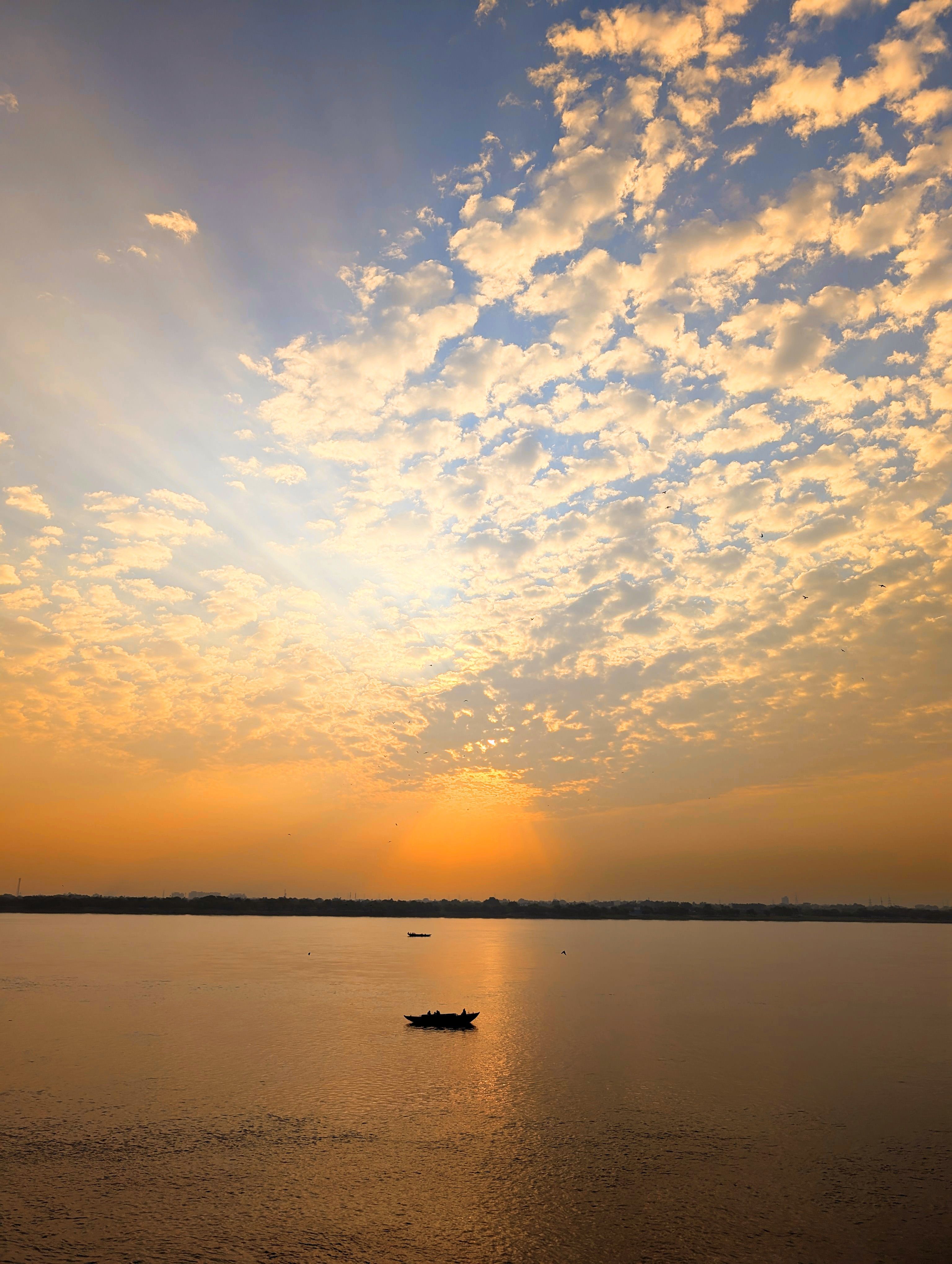 Golden sunrise over the Ganges with a lone boat — Varanasi