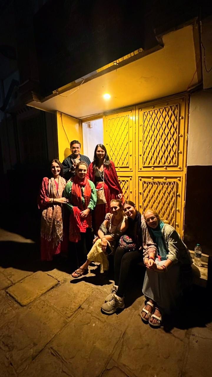 Travellers posing outside the yellow hostel door at night